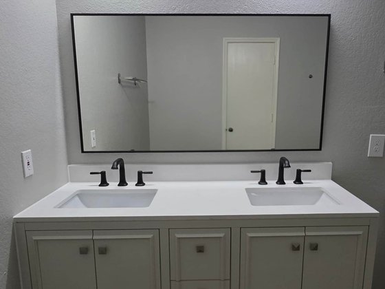 Bathroom with a white double vanity and wide mirror