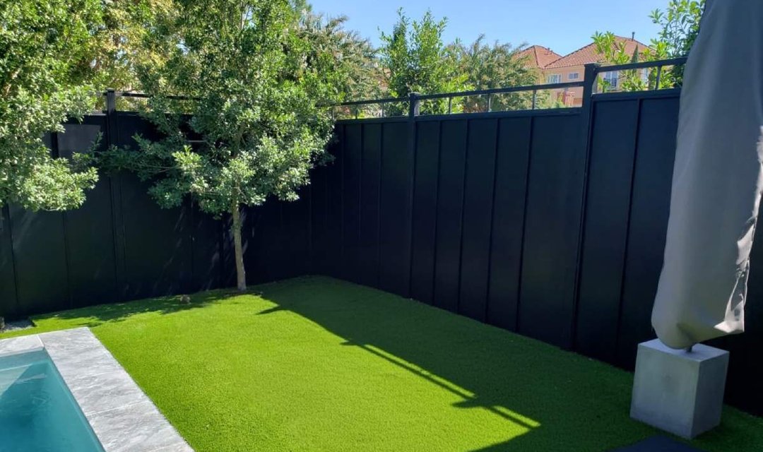 Black wood privacy fence around a backyard