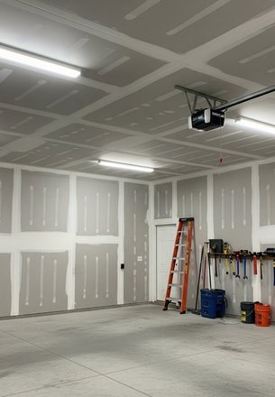 painter back-rolling primer on Hardie siding