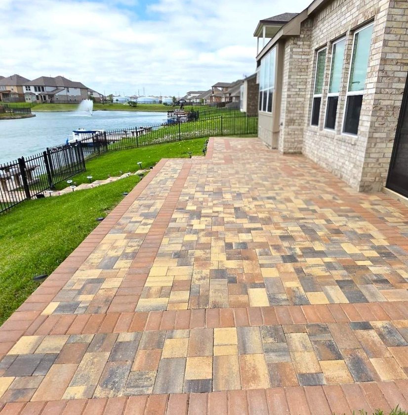 Multi-color paver patio behind a brick home