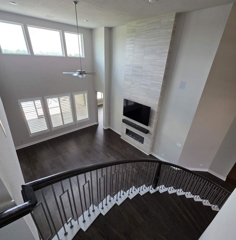 Two-story living room with a fireplace, seen from the staircase