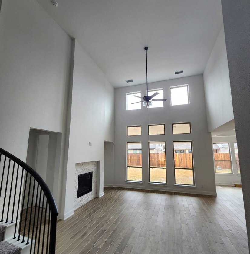 Two-story family room with tall windows and a fireplace