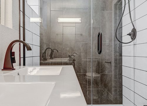 walk-in shower with glass panels and gray tile