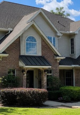 brick home with lap siding on the upper gables