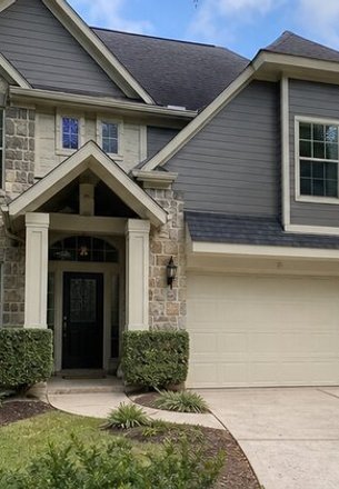 two-story home with stone and gray lap siding